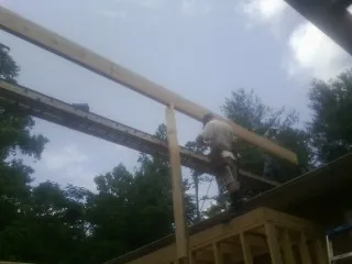 Carpenter setting a ridge beam over a new addition frame — Ice Dam Removal by Roofing Brothers in Earlysville