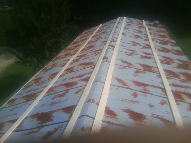 Rusted metal roof panels with new wood purlins before replacement — Storm Damage Roof Repair in Earlysville by Roofing Brothers