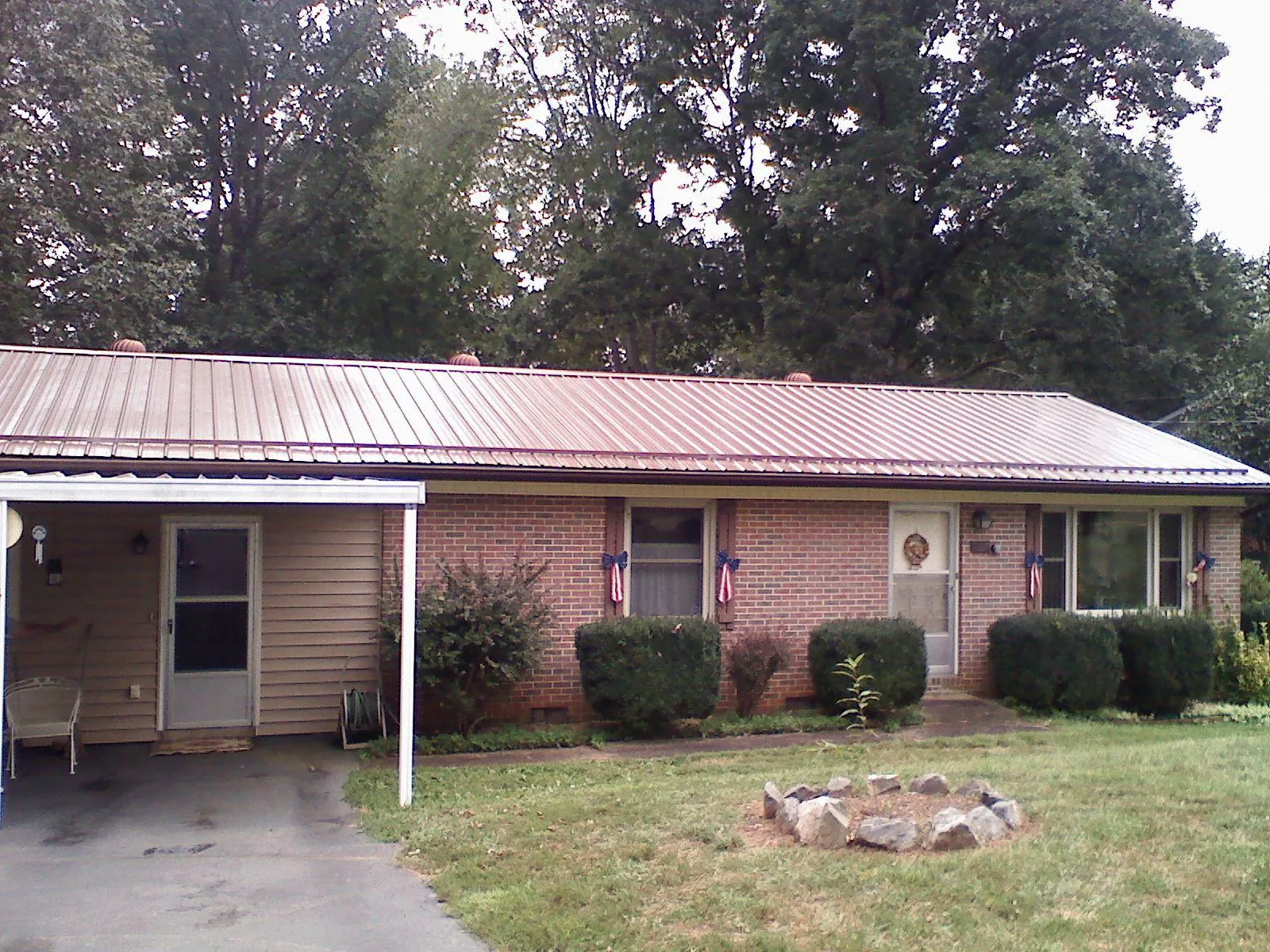 Bronze metal roof and carport on a brick ranch home — Roof Repair work by our crew in Earlysville